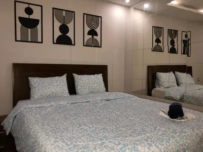 a black cat sitting on a bed in a bedroom at CAN25 2ch au centre de mohammedia in Mohammedia