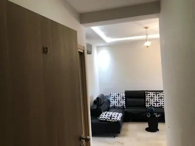 a living room with a black couch in a room at CAN25 2ch au centre de mohammedia in Mohammedia
