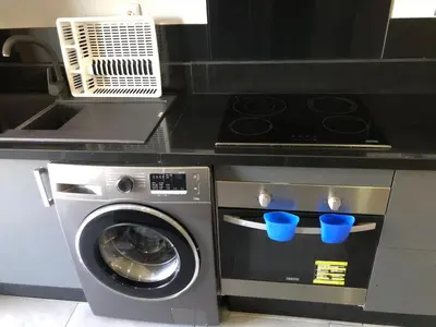 a kitchen with a washing machine with blue cups at CAN25 2ch au centre de mohammedia in Mohammedia