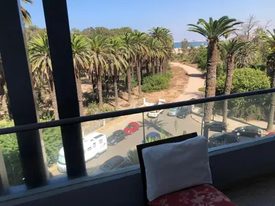 a balcony with a view of a street with palm trees at CAN25 2ch au centre de mohammedia in Mohammedia