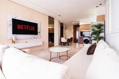a living room with a white couch and a tv at C06 Apartment - Luxury, Style & Wellness in Casablanca