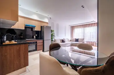 a kitchen and living room with a glass table at C06 Apartment - Luxury, Style & Wellness in Casablanca