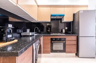 a kitchen with a white refrigerator and wooden cabinets at C06 Apartment - Luxury, Style & Wellness in Casablanca