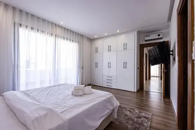 a bedroom with a white bed and a television at Villa Indigo in Rabat
