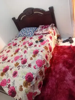 a bed with a floral comforter on it at Belle chambre pour 2 sidi maarouf in Casablanca