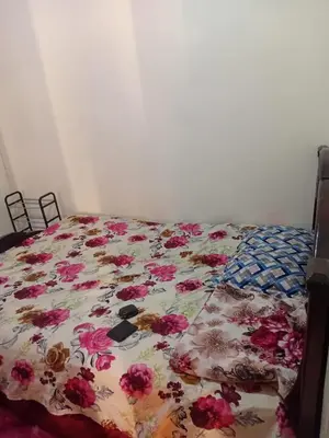 a bed with a floral comforter on it at Belle chambre pour 2 sidi maarouf in Casablanca
