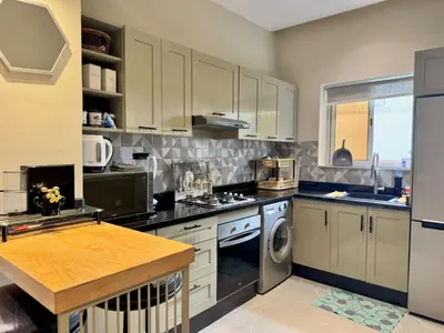 a kitchen with white cabinets and a dishwasher at Appartement à 2 min Gare agdal in Rabat