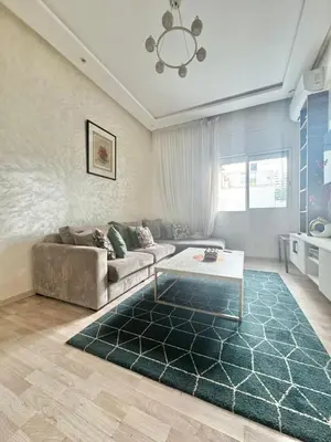 a living room with a couch and a table at Appartement à 2 min Gare agdal in Rabat