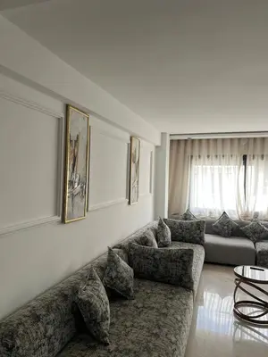 a living room with a couch and a table at L'osmo - 1 BR - 2m from CFC in Casablanca