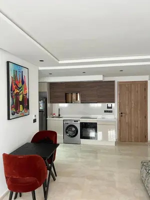 a living room with a table and a kitchen at L'osmo - 1 BR - 2m from CFC in Casablanca