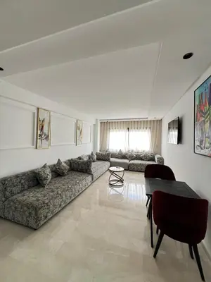 a living room with a couch and a table at L'osmo - 1 BR - 2m from CFC in Casablanca