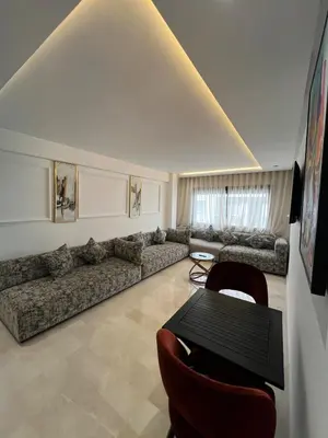 a living room with a couch and a table at L'osmo - 1 BR - 2m from CFC in Casablanca
