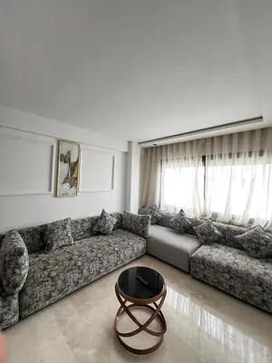 a living room with a couch and a coffee table at L'osmo - 1 BR - 2m from CFC in Casablanca