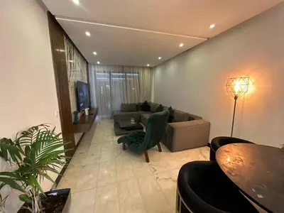 a living room with a couch and a table at Luxury Modern Apartment in the Heart of the City with Balcony Overlooking Twin Towers in Casablanca