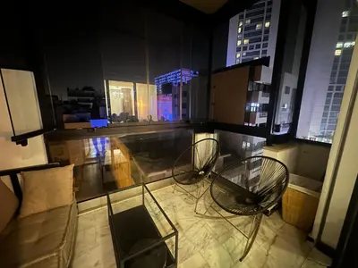 two chairs and a table in a room with windows at Luxury Modern Apartment in the Heart of the City with Balcony Overlooking Twin Towers in Casablanca