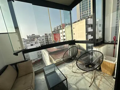 a living room with a couch and chairs on a window at Luxury Modern Apartment in the Heart of the City with Balcony Overlooking Twin Towers in Casablanca