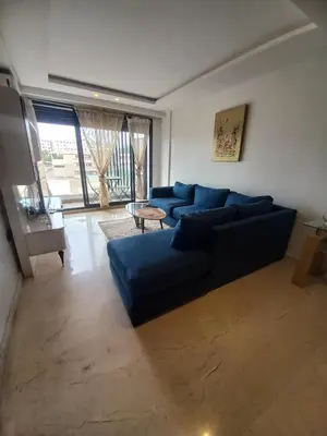 a living room with a blue couch and a table at La perle home 21 in Casablanca-Port