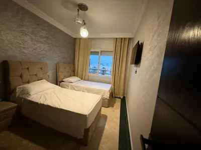 a bedroom with two beds and a window at Aziz in Casablanca