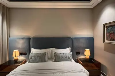 a bedroom with a large bed with two lamps at Anfa The Address - By AppartAli in Casablanca