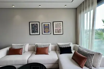 a living room with a white couch with pillows at Anfa The Address - By AppartAli in Casablanca