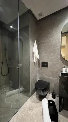 a bathroom with a shower and a black toilet at The Address to Ocean - By AppartAli in Casablanca