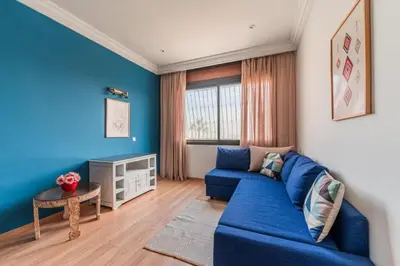 a blue living room with a blue couch and a table at Appartement Cosy et central in Casablanca