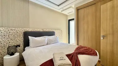 a bedroom with a bed and a wooden door at Casa Stop Spot - AppartAli in Casablanca