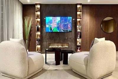 a living room with two white chairs and a tv at State of Peace in Marina - By AppartAli in Casablanca