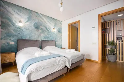 a bedroom with a large bed with a painting on the wall at La Terrazza at Marina - By AppartAli in Casablanca