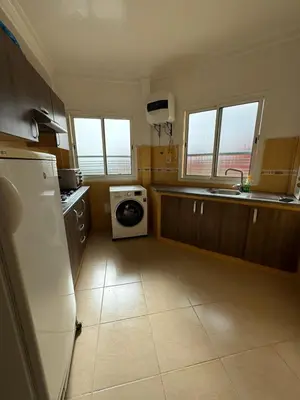 a kitchen with a refrigerator and a washing machine at Apartement en Wifak Soleil, calme et sécurité in Temara