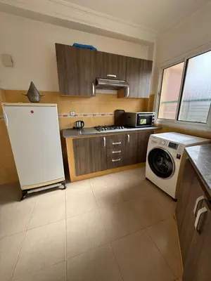 a kitchen with a refrigerator and a washing machine at Apartement en Wifak Soleil, calme et sécurité in Temara