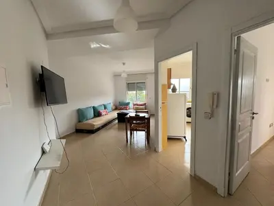 a living room with a couch and a table at Apartement en Wifak Soleil, calme et sécurité in Temara