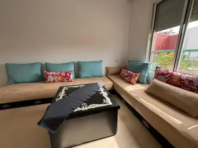 a living room with a couch and a window at Apartement en Wifak Soleil, calme et sécurité in Temara