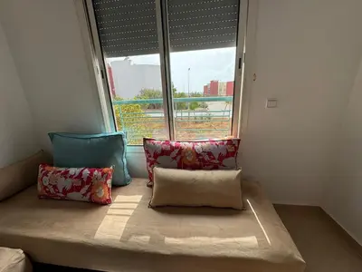 a bed with two pillows in a room with a window at Apartement en Wifak Soleil, calme et sécurité in Temara