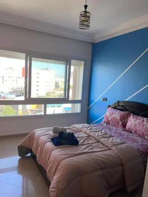 a bedroom with a large bed with a blue wall at Furnished apartment in the middle of the city in Casablanca