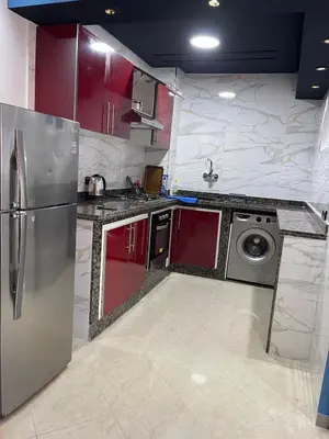 a kitchen with red cabinets and a stainless steel refrigerator at Furnished apartment in the middle of the city in Casablanca