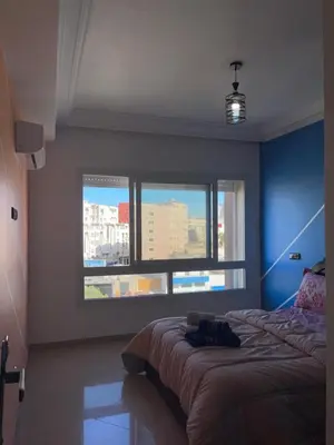 a bedroom with a bed and a large window at Furnished apartment in the middle of the city in Casablanca