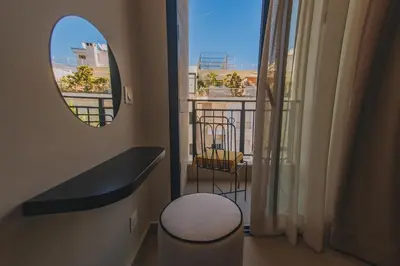 a bathroom with a mirror and a stool and a balcony at Dally Apart Hotel in Rabat