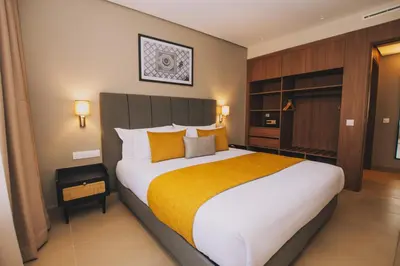 a bedroom with a large bed with orange and white pillows at Dally Apart Hotel in Rabat