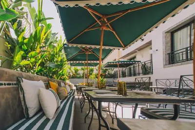 an outdoor patio with tables and chairs and plants at Dally Apart Hotel in Rabat