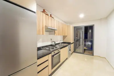 a kitchen with wooden cabinets and stainless steel appliances at Modern apartment with pool view Tamaris in Tamaris