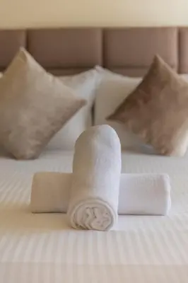 a stack of towels sitting on a bed at 3BR Apartment in Prestigious Hay Riad by MERAT HOME in Rabat