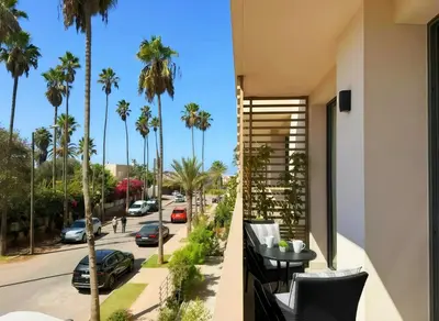 a balcony with a view of a street with palm trees at Maya Suites - Opale Sea Side in Anfa-Supérieur