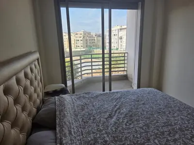 a bedroom with a bed and a large window at Appartement vue sur le phare in Casablanca