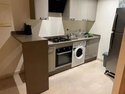 a kitchen with a stove and a washing machine at Appartement vue sur le phare in Casablanca