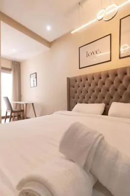 a bedroom with a large white bed with a headboard at Appartement élégant a Parc Mohammedia - proche de la mer in Mohammedia