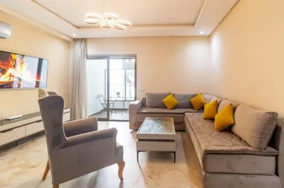 a living room with a couch and a chair at Appartement élégant a Parc Mohammedia - proche de la mer in Mohammedia