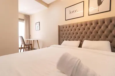 a bedroom with a large white bed with a large headboard at Appartement élégant a Parc Mohammedia - proche de la mer in Mohammedia