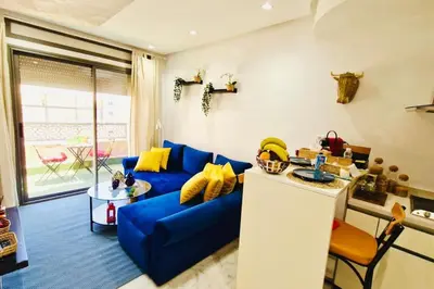 a living room with a blue couch and yellow pillows at Fundays Stay Casablanca in Casablanca