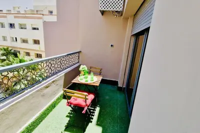 a balcony with a table and chairs on it at Fundays Stay Casablanca in Casablanca